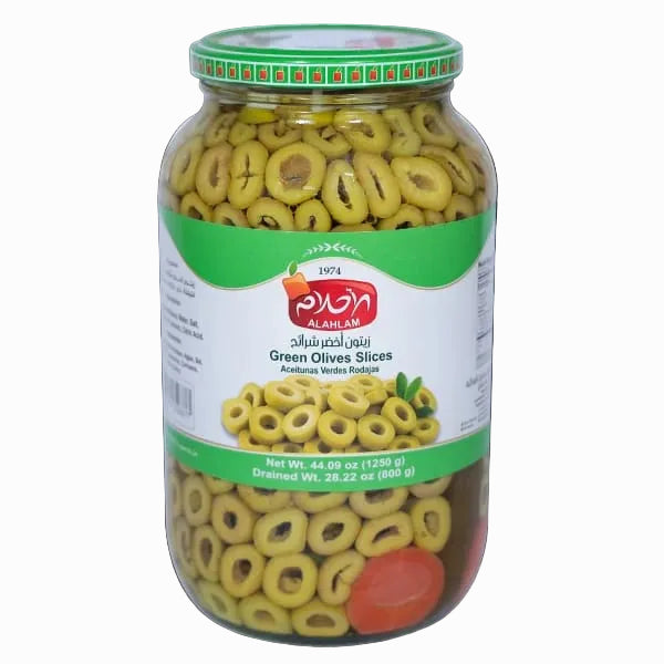 A glass jar of Al Ahlam brand sliced green olives with a green and white label, set against a solid black background.