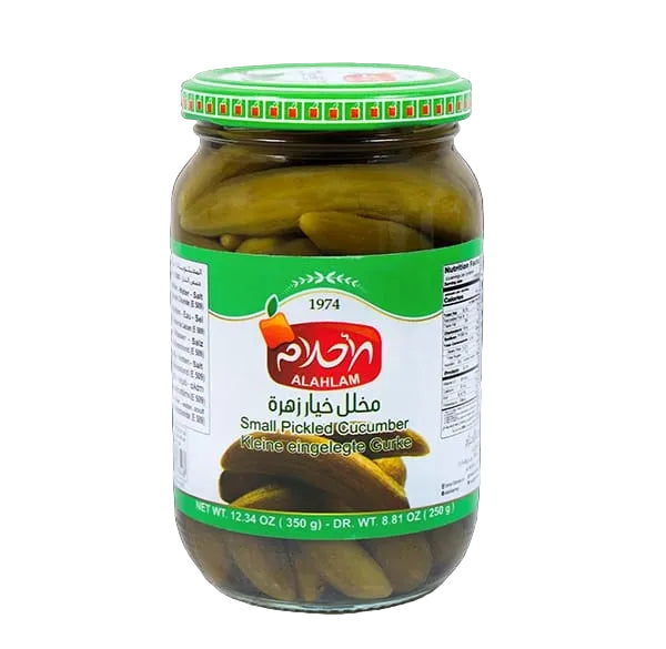 A glass jar of Alahlam Pickled Cucumbers against a solid black background. The jar contains green pickles and has a green and white label with the red Alahlam logo.