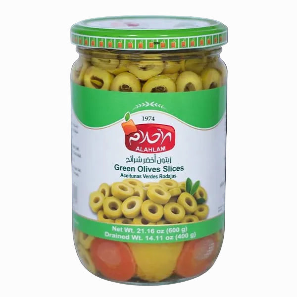 A glass jar of Al-Ahlam Green Olives Slices on a solid black background. The jar has a green and white label with a red Al-Ahlam logo, showing the sliced green olives inside.
