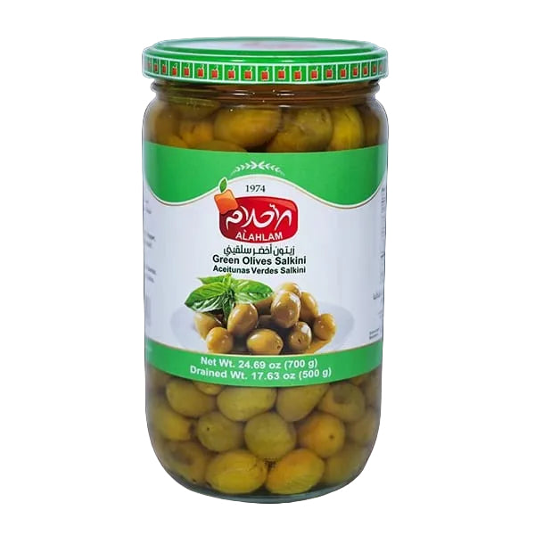 A glass jar of Al-Ahlam Green Olives Saakini (Acehnman Verdes Saakini) with a green and white label, set against a solid black background.