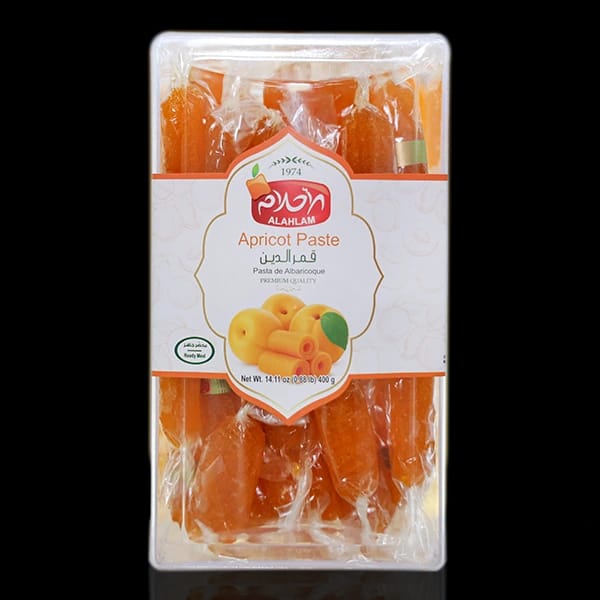 A package of Alahlam Apricot Paste in a clear plastic clamshell container with a white and orange label, set against a solid black background.