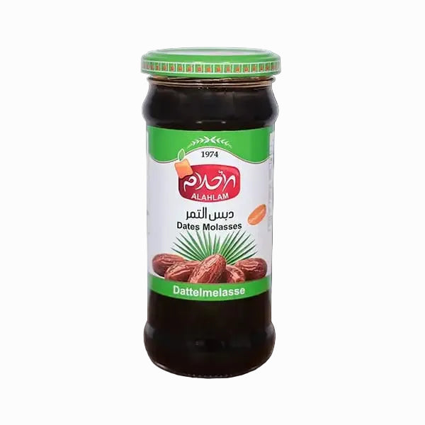 A glass jar of Al-Ahlia Dattel Molasse (datt jam) with a green lid and a white label featuring green and red branding, set against a solid black background.